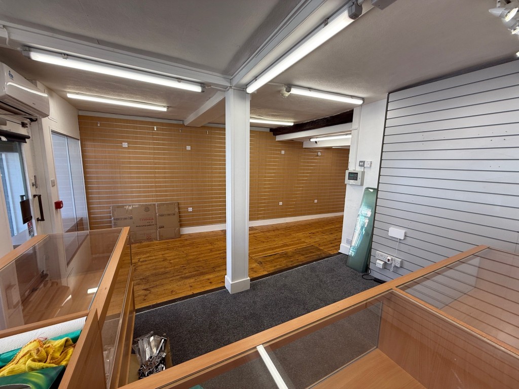 Lot: 37 - COMMERCIAL PROPERTY WITH SELF-CONTAINED SPLIT LEVEL FLAT ABOVE - Viewi of the shop from behind the sales counter